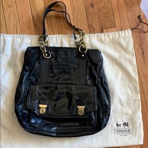 Black coach bag with gold straps and pink lining